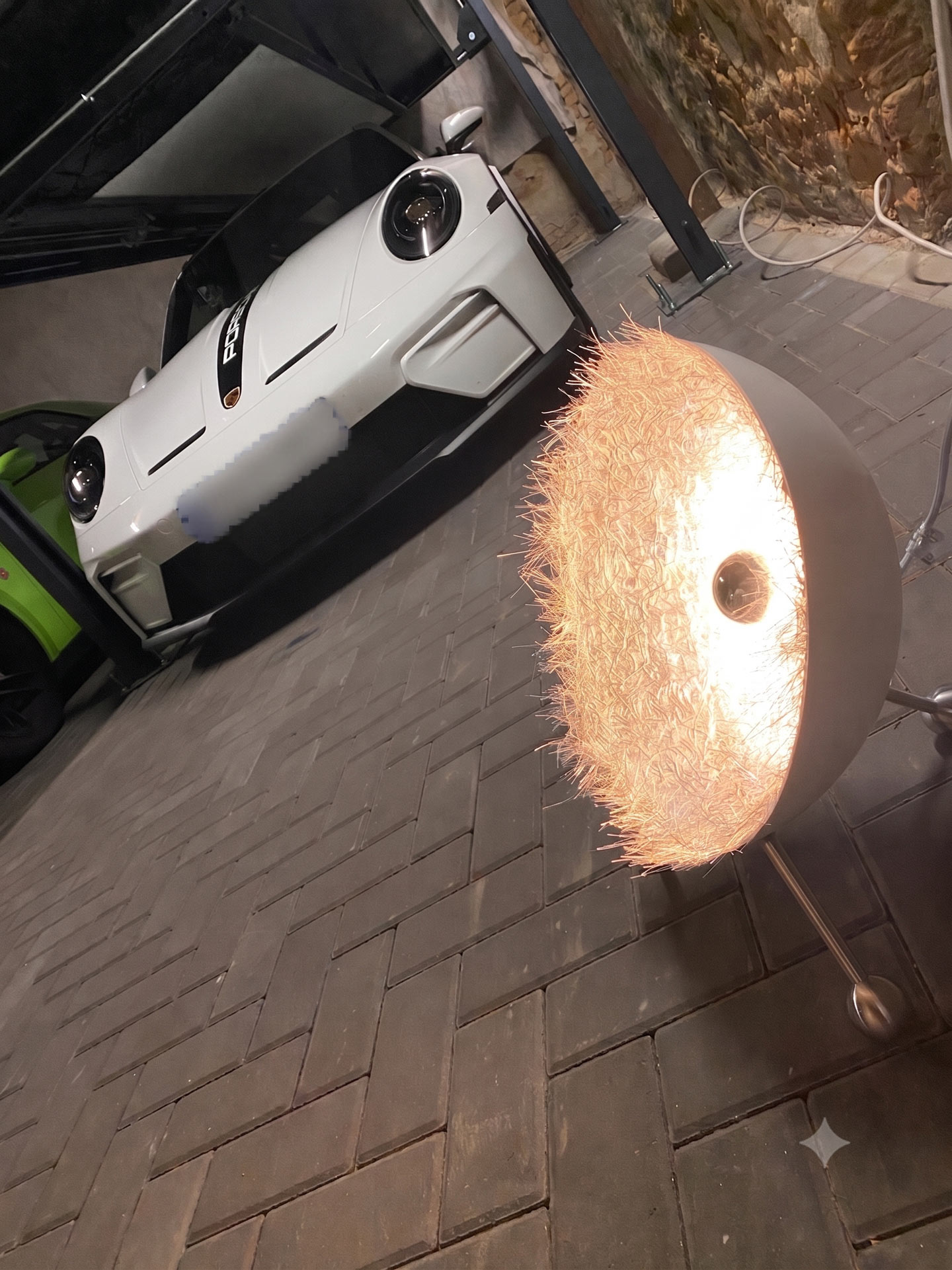 Weisser Sportwagen in Garage neben leuchtender Lampe mit Kupferfasern